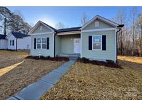 Charming one-story home with green siding, black shutters, and a well-manicured front yard at 709 Queens Ct, Gastonia, NC 28052