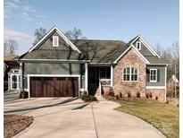 Gray craftsman style home with stone accents, a 3-car garage, and a landscaped yard at 7535 Rabbit Cir, Denver, NC 28037