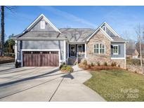 Charming home featuring stone accents, a two-car garage, and a well-manicured front yard at 7535 Rabbit Cir, Denver, NC 28037