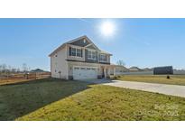 Two story home featuring a two car garage, covered porch and nice lawn at 821 Bethesda Rd, Statesville, NC 28677