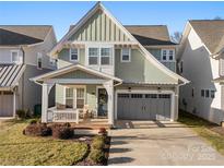 Charming two-story home featuring a welcoming front porch and a two-car garage at 907 Millbrook Rd, Charlotte, NC 28211