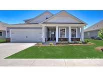 New construction home with gray siding, white trim, and a landscaped lawn at 110 Sari St, Troutman, NC 28166