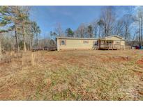 Tan mobile home with a large yard and covered porch at 1301 Brandy Ln # 7, Shelby, NC 28152