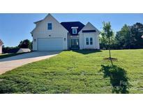 Charming cream-colored, two-story home with a well-manicured lawn and attached two-car garage at 136 Autumn Blaze Rd, China Grove, NC 28023
