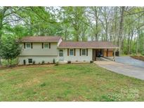 Charming split-level home featuring a well-manicured lawn, painted brick, and an attached carport at 170 Woodcrest Rd, Mooresville, NC 28115