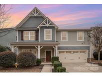 Charming two-story home featuring a well-manicured lawn, covered front porch, and integrated two-car garage at 2201 Bluebell Way, Tega Cay, SC 29708