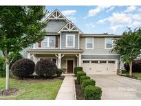 Charming two-story home with an attached two-car garage, landscaped front yard, and inviting entryway at 2201 Bluebell Way, Tega Cay, SC 29708