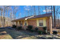 Brick ranch house with covered porch and mature trees at 3581 Thompson St, Newton, NC 28658