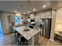 Bright kitchen featuring granite counters, island with bar seating, and stainless steel appliances at 604 Cassidy Ct, Clover, SC 29710