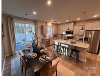 Open-concept kitchen and dining area featuring granite countertops and stainless steel appliances and an island with barstool seating at 616 Cassidy Ct, Clover, SC 29710