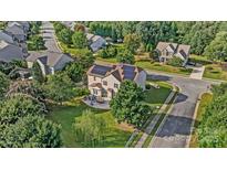 Stunning aerial view of a house with solar panels, a patio, and lush landscaping at 712 Springwood Dr, Waxhaw, NC 28173