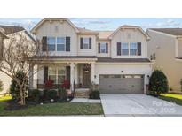 Charming two-story home featuring a covered front porch and a two-car garage at 840 Pecan Tree Ln, Fort Mill, SC 29715