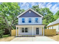 Charming two-story home featuring a covered front porch and new, light-colored wood fencing at 204 N Yadkin Ave, Spencer, NC 28150