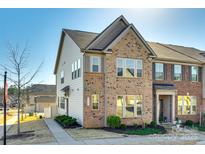 Charming two-story brick and siding townhome with well-maintained landscaping and inviting curb appeal at 5373 Orchid Bloom Dr, Indian Land, SC 29707