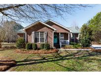 Brick ranch house with landscaped yard and teal front door at 665 Edwards Rd, Fort Lawn, SC 29714