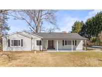 Charming ranch home with gray siding, covered porch, and detached garage at 115 E Texas Ave, Bessemer City, NC 28016