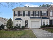 Charming townhome with a one-car garage, neat landscaping, and classic black and white facade at 141 N Arcadian Way, Mooresville, NC 28117