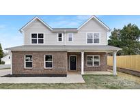 Charming two-story home showcasing a blend of grey siding and brick with a well-manicured lawn at 14309 King Eider Dr, Charlotte, NC 28273