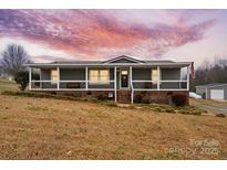 Gray mobile home with wrap-around porch and American flag at 15918 Big Bear Rd, Albemarle, NC 28001