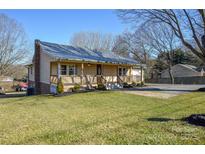 Charming home featuring a cozy front porch, well-maintained lawn, and convenient driveway at 236 Ervin Rd, Mooresville, NC 28117