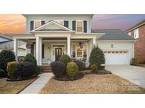 Two-story house with a front porch, brick accents, and a two-car garage at 328 Sensibility Cir, Fort Mill, SC 29708