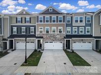 Attractive townhouse exteriors with stone accents, individual garages, and manicured lawns at 432 Burr St, Indian Trail, NC 28079