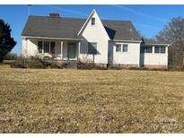 Charming exterior of a home featuring a covered front porch and a well-maintained lawn under a clear blue sky at 897 Mocksville Hwy, Statesville, NC 28625