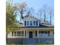 Charming two-story home featuring a covered front porch and classic black shutters against a bright white facade at 105 N Inman Ave, Bessemer City, NC 28016