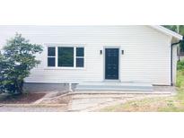 Exterior of a white home featuring a dark front door, a window, and meticulously laid stone steps at 105 N Inman Ave, Bessemer City, NC 28016