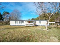 Charming one-story home featuring a front porch, carport and well-maintained lawn and blue sky at 3765 Killian Rd, Lincolnton, NC 28092