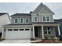 Charming two-story home with gray siding, stone accents, and a two-car garage at 7120 Wayfarer Dr # 0079, Charlotte, NC 28269