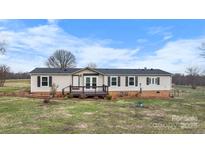 Charming ranch style home with a covered front porch and well-maintained landscaping at 760 Tomlin Mill Rd, Statesville, NC 28625