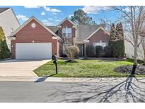 Charming brick home featuring a well-manicured lawn and attached two-car garage at 1027 Fountainbrook Dr, Indian Trail, NC 28079