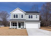 Two-story home featuring a two-car garage, green door, gray siding, and a manicured lawn at 116 Durham Rd, Stanley, NC 28164