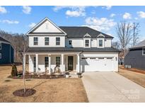 Two-story white house with gray roof, front porch, and attached two-car garage at 122 Still Creek Dr, Mooresville, NC 28115