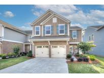 Charming two-story home featuring a brick facade, two-car garage, and attractive blue shutters at 1244 Scotch Meadows Loop, Monroe, NC 28110