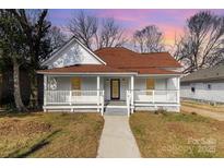 Charming renovated home featuring a white exterior, red roof, and front porch at 1712 S Main St, Salisbury, NC 28144