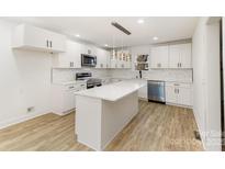 Bright kitchen featuring white cabinetry, stainless appliances, and a center island with pendant lighting at 1712 S Main St, Salisbury, NC 28144