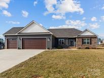 Charming single-story home featuring a three-car garage and stone facade accents at 200 Staffordshire Dr, Statesville, NC 28625