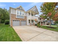 Two-story house with gray siding, stone accents, and a two-car garage at 3205 Helmsley Ct, Concord, NC 28027