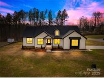 Stunning home featuring a modern farmhouse design with a manicured lawn and professional landscaping at 4011 Brandy Creek Ct, Clover, SC 29710