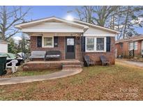 Charming brick home featuring a cozy front porch with seating and traditional architectural details at 453 Bynum Ave, Rock Hill, SC 29732