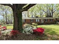 Charming brick home featuring colorful landscaping with red and white azalea bushes in the front yard at 725 Plantation Rd, Lancaster, SC 29720
