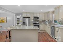 An eat-in kitchen showcasing stainless steel appliances, a granite countertop, and mosaic backsplash at 725 Plantation Rd, Lancaster, SC 29720