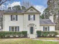 Charming white brick two-story home featuring manicured landscaping and traditional architectural details at 11143 Coachman Cir, Charlotte, NC 28277