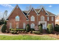 Charming red brick home boasts meticulous landscaping and striking architectural details at 1604 Windy Ridge Rd, Charlotte, NC 28270