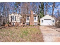 Charming split-level home with brick chimney, detached garage and inviting curb appeal at 3029 Winding Trl, Matthews, NC 28105