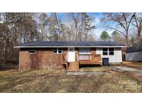 Brick ranch house with wooden deck and small yard at 704 W Border St, Dallas, NC 28034