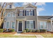 Two-story townhome with gray siding, black shutters, and landscaping at 104 N Canyon Ridge Dr, Mount Holly, NC 28120