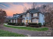 Charming brick home featuring well-manicured landscaping and a welcoming entrance with a small balcony above at 10417 Sutherby Dr, Charlotte, NC 28277